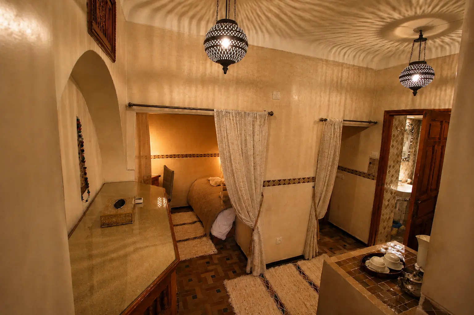 The studio from the entrance, with hanging lanterns and a curtained alcove